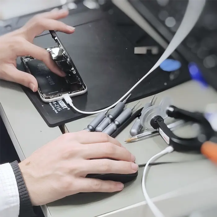 Technicien réparant un smartphone en atelier